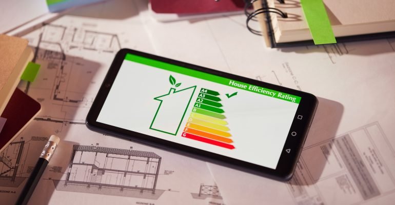 Energy class and efficiency app on phone over architectural plans